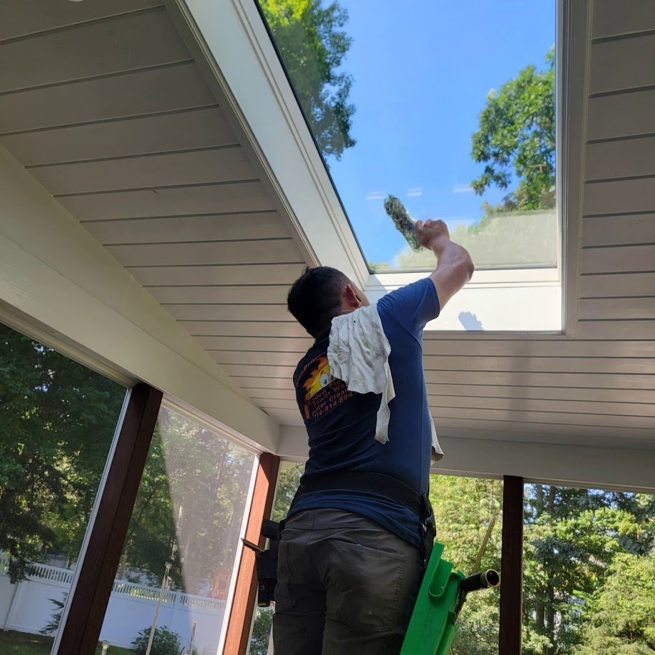 Sunbright Cleaning crew member cleaning an upper window